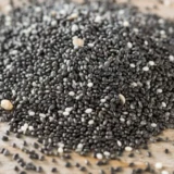 Organic chia seeds spilled on a wooden surface
